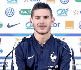 a man wearing a blue nike jacket stands in front of a microphone