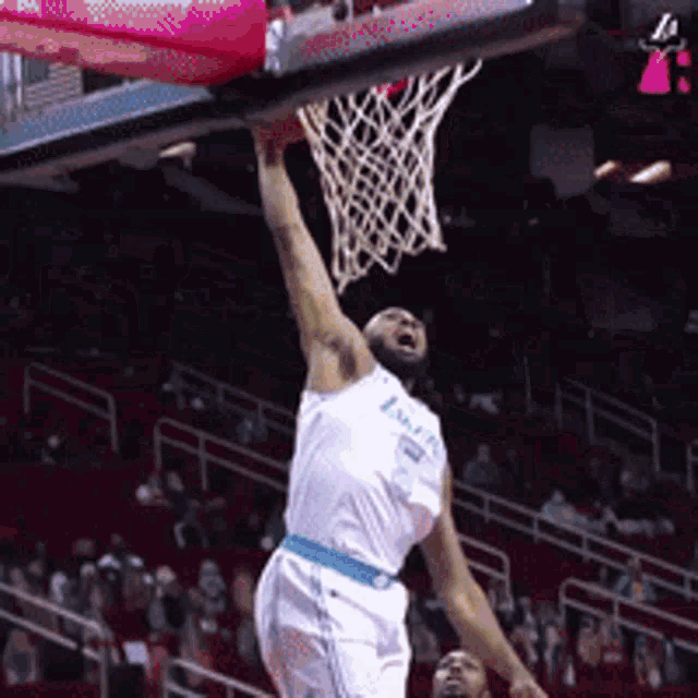 a basketball player is jumping in the air to dunk the ball into the net