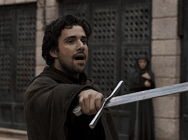 a man with a beard is holding a large sword