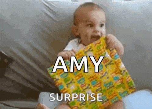 a baby is holding a gift with the name amy surprised