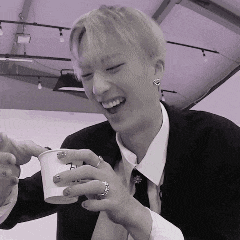 a man in a suit and tie is holding a cup of coffee and smiling