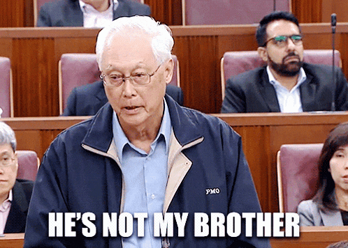 a man sitting in a classroom with the words he 's not my brother above him