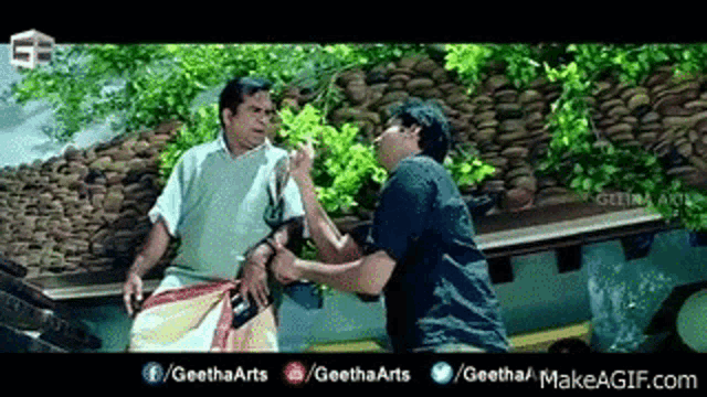 two men are standing next to each other on a roof and talking to each other .