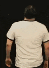 the back of a man wearing a white t-shirt and a hat is shown .