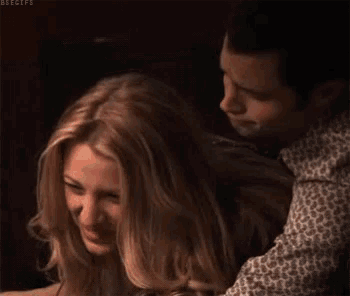 a man is hugging a woman who is smiling and laughing .
