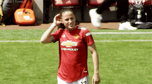a female soccer player wearing a red shirt with chevrolet on it