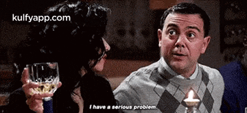 a man is talking to a woman while holding a glass of wine and says i have a serious problem .