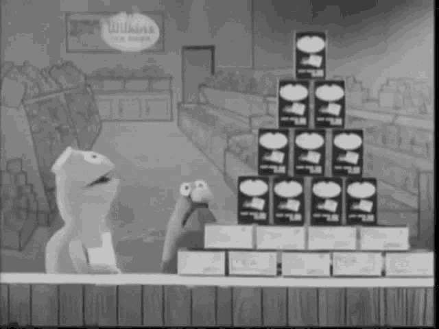 two muppets are standing in front of a stack of wilkins tea cans