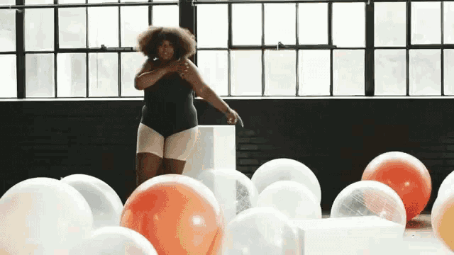 a woman is surrounded by balloons and a window