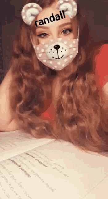a girl wearing a teddy bear face mask with randall written on her face