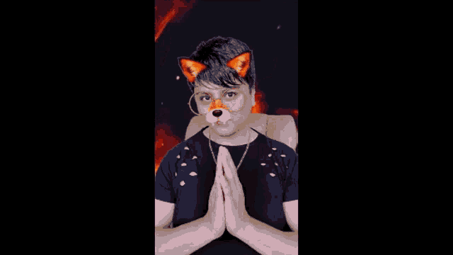 a man wearing a fox mask and glasses is clapping his hands in front of a fire background