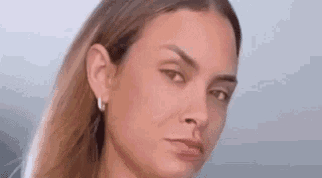 a close up of a woman 's face with a sad look on her face .