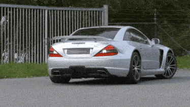 a silver sports car is parked on the side of the road