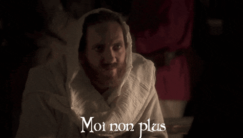 a man with a beard is wearing a white robe with the words moi non plus written on the bottom