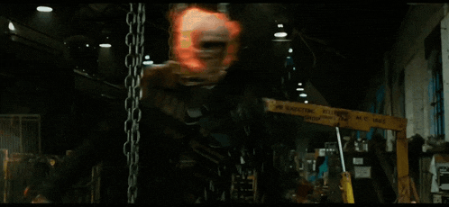 a man is hanging from chains in a dark room