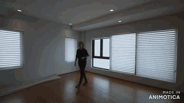 a woman is walking in an empty room with the words made in animatica on the bottom