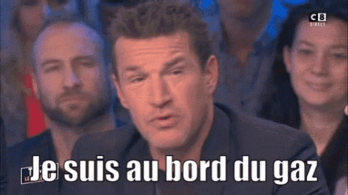 a man in a suit says je suis au bord du gaz in front of a group of people