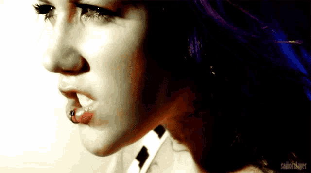 a close up of a woman 's face with purple hair