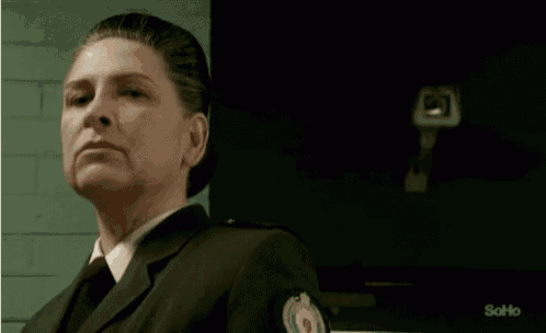 a woman in a suit and tie is sitting in front of a soho television .
