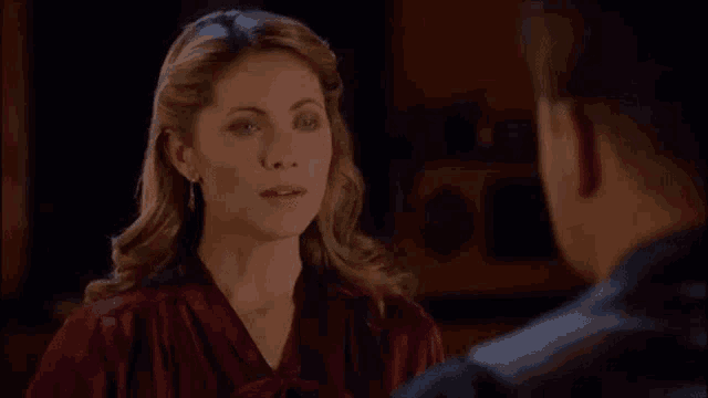 a woman in a red top looks at a man