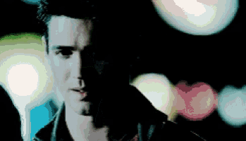 a close up of a man 's face with a blurry background of lights