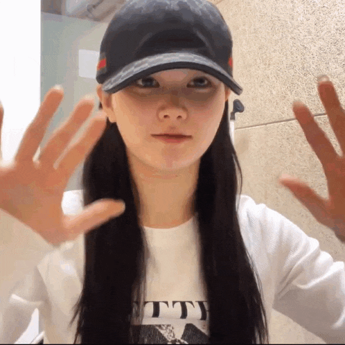 a woman wearing a black hat and a white shirt that says tty