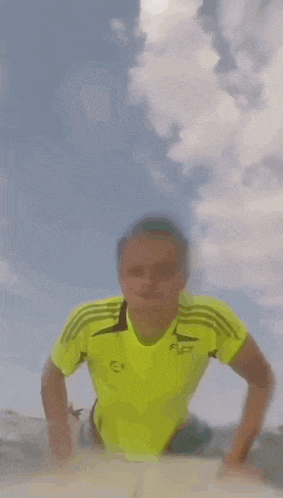 a person in a yellow shirt is running on a beach