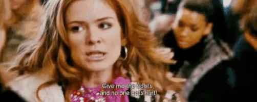 a woman in a pink dress is talking to another woman in a crowd of people .