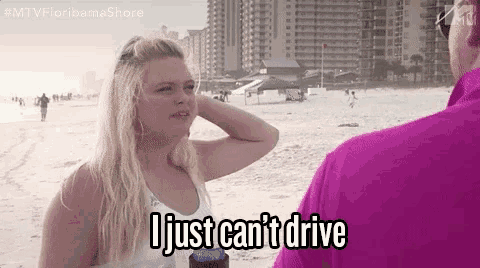 a woman is talking to a man on the beach and says `` i just can t drive '' .