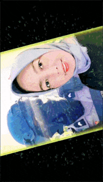 a woman wearing a hijab and a helmet is displayed on a cell phone screen