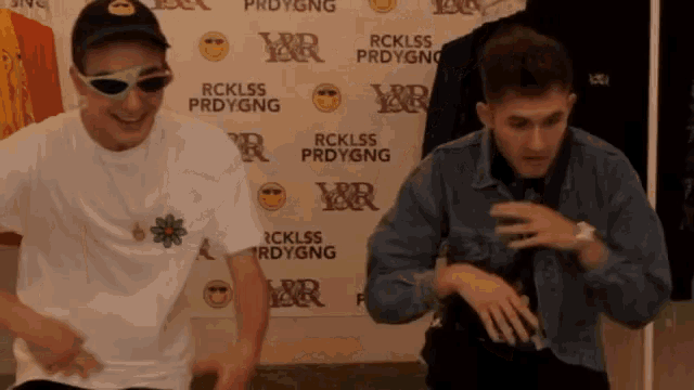 two young men are dancing in front of a wall that says rcklss prdygng