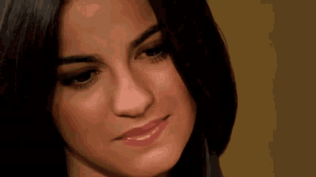 a close up of a woman 's face with a slight smile