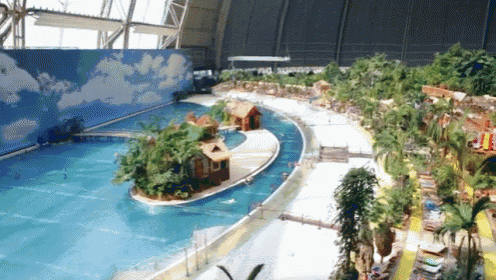 a large swimming pool with a house on a small island in the middle
