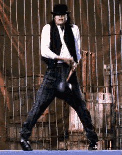 a man in a black hat is swinging a bat at a ball