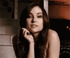 a naked woman with long hair is looking at the camera .