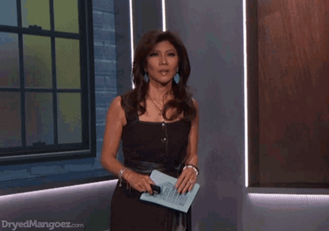 a woman in a black dress stands in front of a window and dryedmangoez.com