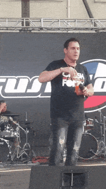 a man wearing a shirt that says ' texas for ' on it stands on stage