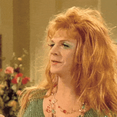 a woman with red hair and green eye shadow