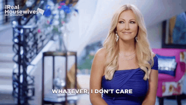 a woman in a blue dress is saying " whatever i don 't care "