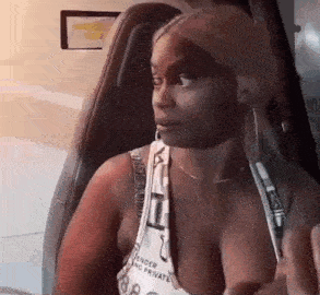 a woman is sitting in the driver 's seat of a car looking at the camera .