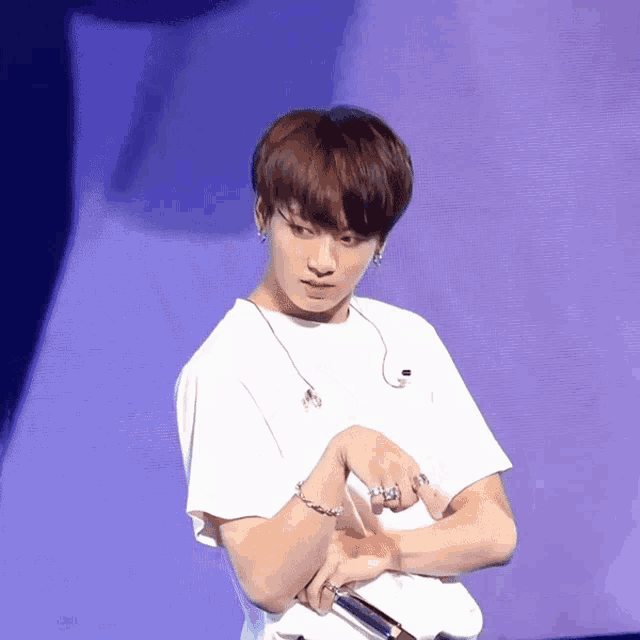 a man in a white shirt is holding a microphone in his hand