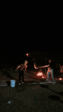 a man is standing in front of a fireworks display with fireworks coming out of his face .