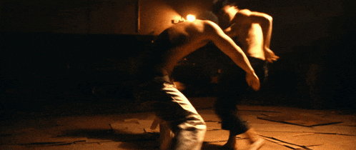 a man without a shirt is standing in the dark