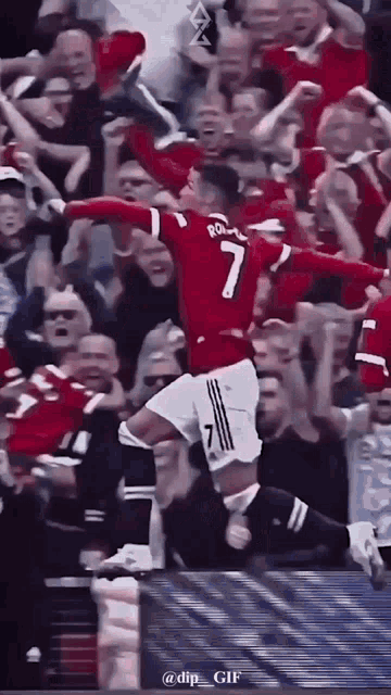a soccer player is jumping in the air in front of a crowd while wearing a red jersey with the number 7 on it .
