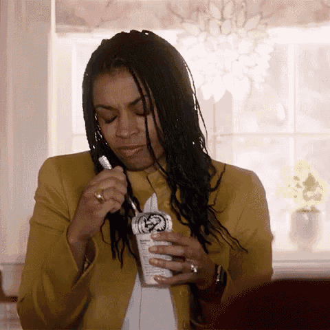 a woman in a yellow jacket is brushing her teeth with a toothbrush .