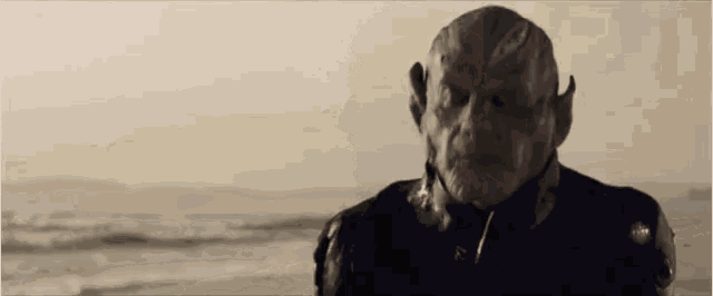 a man with a mask on his face is standing on a beach .