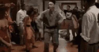 a man is dancing in front of a crowd at a party .