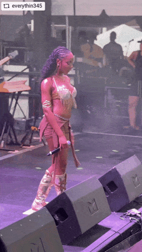 a woman stands on a stage holding a microphone with the words everything345 on the bottom
