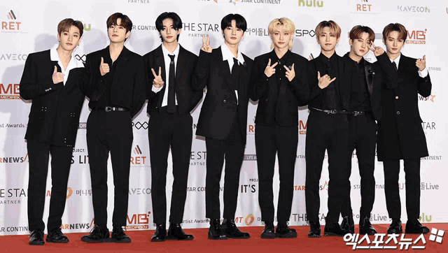 a group of young men are posing for a picture on a red carpet sponsored by hulu