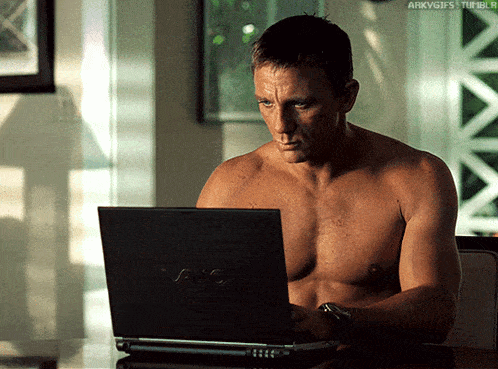 a shirtless man is typing on a vaio laptop computer